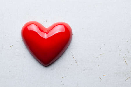 Blank wooden plate in wooden hand and red hearts in backgroundの写真素材