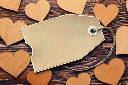 Blank paper label and wooden hearts on planks backgroundの写真素材