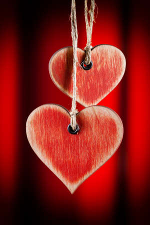 Two wooden hearts on red backgroundの写真素材