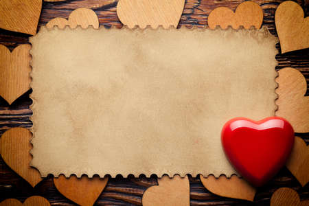 Red heart and blank paper sheet on wooden backgroundの写真素材
