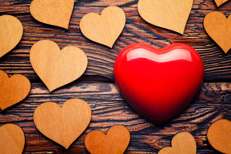 Red heart and group of wooden hearts on wooden tableの写真素材