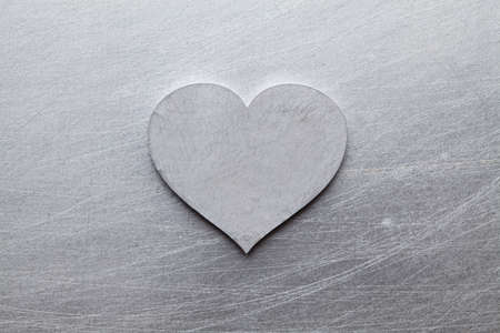 Silver heart on scratched metal  backgroundの写真素材