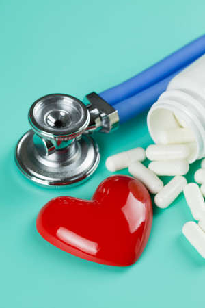 Stethoscope, pills and figure in the shape of heart as a symbol of healthcareの写真素材