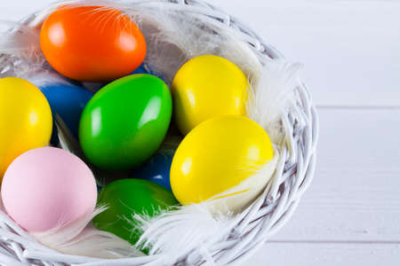 Colored easter eggs in the basket on a white backgroundの写真素材