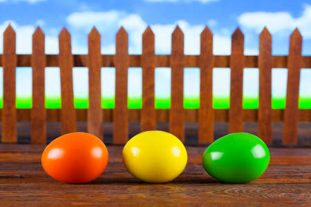 Three easter eggs on wooden table and nature backgroundの写真素材