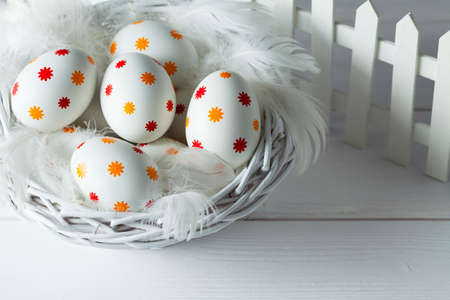 Patterned easter eggs in the basket on wooden tableの写真素材