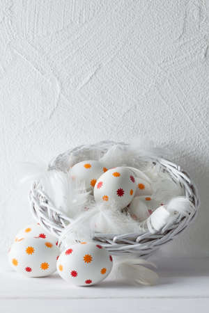Patterned easter eggs in the basket on wooden tableの写真素材