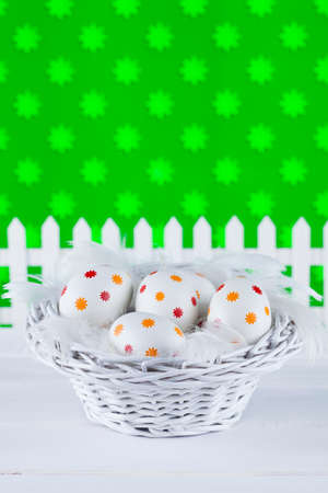 Easter eggs in the basket on patterned backgroundの写真素材