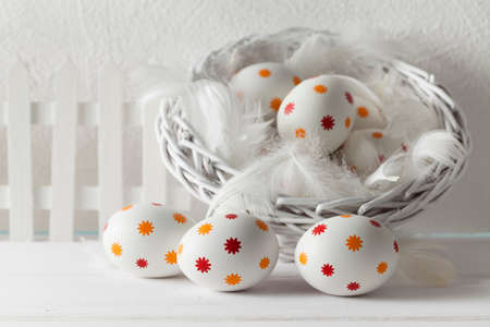Patterned easter eggs in the basket on wooden tableの写真素材