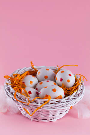 Easter eggs in the nest and basket on pink backgroundの写真素材