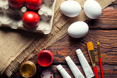 Easter eggs, paint and brushes on wooden table の写真素材