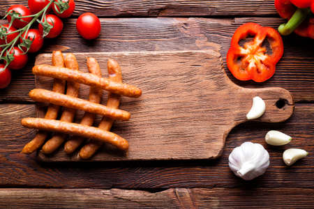 Sausage and vegetables on wooden boardの写真素材