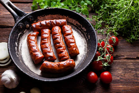 Roasted sausage, fresh vegetables and herbsの写真素材