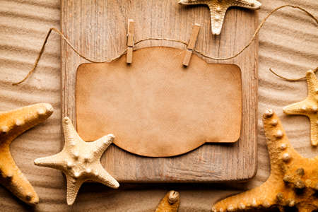 Blank paper sheet and wooden board on the beachの写真素材