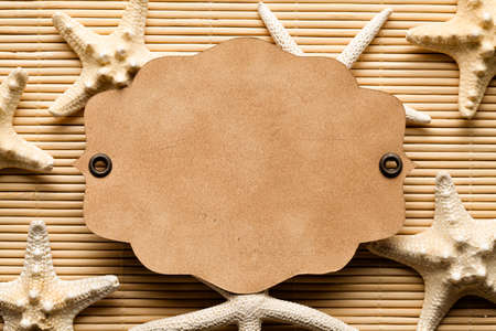 Starfishes and paper card on wooden background or textureの写真素材