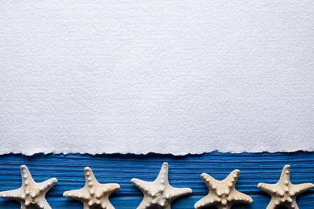 Blank handmade paper sheet and starfish on wooden boardの写真素材