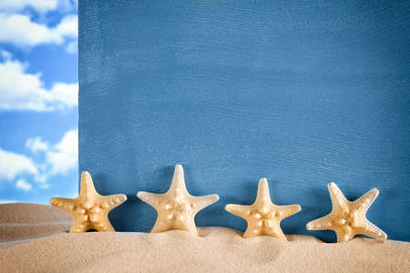 Starfishes and blue sheet on beach sandの写真素材