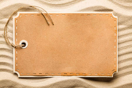 Blank paper label on beach sandの写真素材