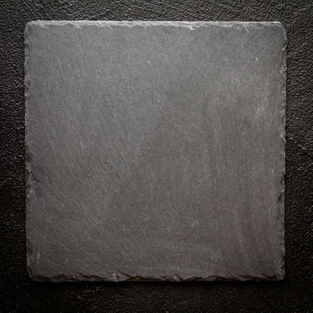 Black stone plate on black surface backgroundの写真素材
