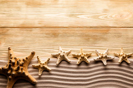 Starfishes, sand and wooden tableの写真素材