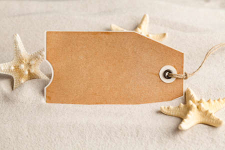 Blank paper sheet and starfish on beach sandの写真素材