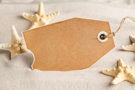 Blank paper sheet and starfish on beach sandの写真素材