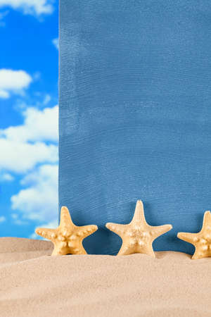 Starfishes and blue sheet on beach sandの写真素材