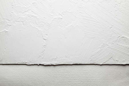 White plaster on the wall and handmade paper sheet background or textureの写真素材
