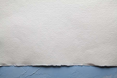 White paper sheet on plastered wall background