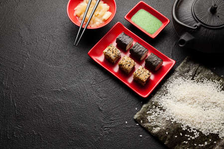 Traditional cuisine - sushi, ginger, wasabi and rice on black backgroundの写真素材
