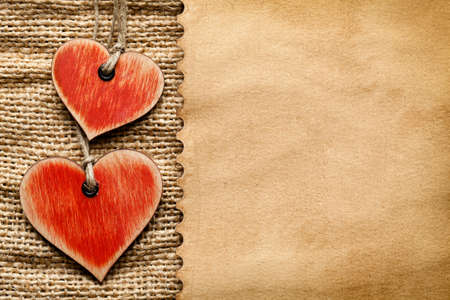 Wooden hearts and paper sheet on fabric backgroundの写真素材