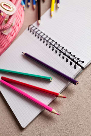 Colorful pencils and notebook on tableの写真素材