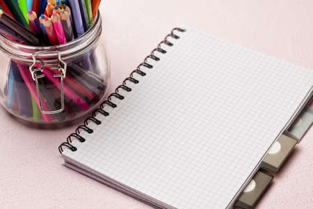 Notebook and colored pencils in a jarの写真素材