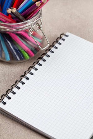 Notebook and colored pencils in a jarの写真素材
