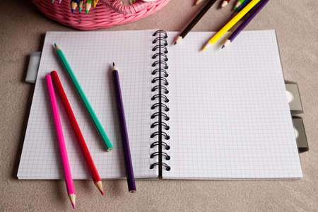 Colorful pencils and notebook on tableの写真素材