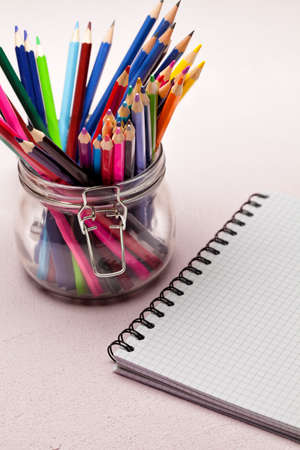 Notebook and colored pencils in a jarの写真素材