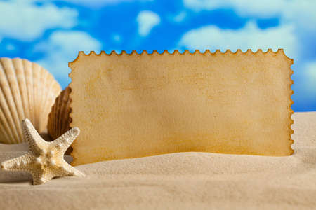 Summer background - blank paper sheet, shell and starfish on beachの写真素材