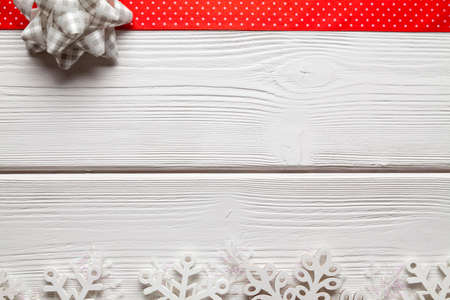 Christmas decorations - snowflakes and red ribbon on white wooden tableの写真素材