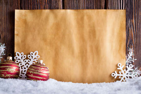 Christmas background - blank paper sheet, snowflakes and baubles on wooden wall backgroundの写真素材