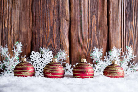 Christmas background - baubles and snowflakes on snow and wooden wallの写真素材