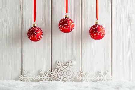 Christmas background - snowflakes and baubles on snow and wooden wallの写真素材