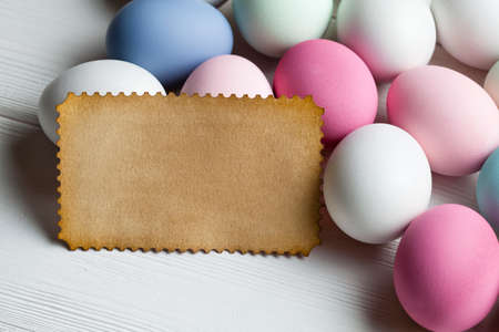 Blank paper sheet and colorful eggs on wooden table