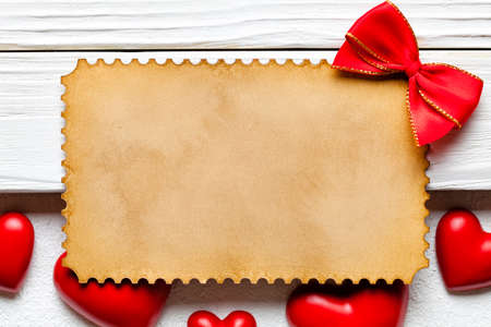 Blank paper sheet, red heart and bow on white backgroundの写真素材