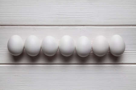 White eggs on white wooden wall backgroundの写真素材