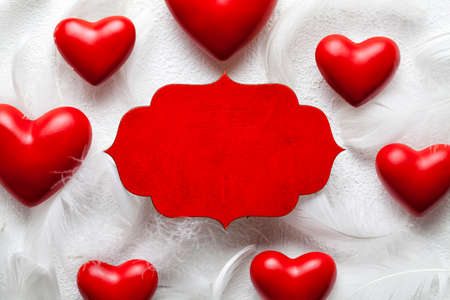 Red wooden label and red hearts on white backgroundの写真素材