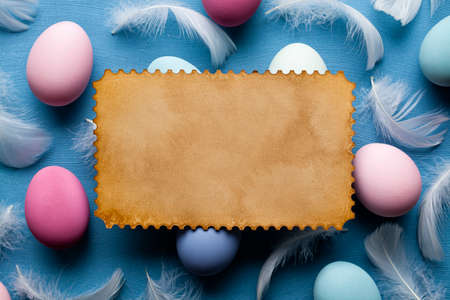 Handmade paper sheet and colored eggs on blue backgroundの写真素材