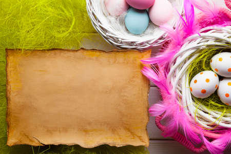 Easter background - White and colored eggs and blank paper sheetの写真素材