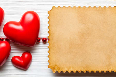 Valentines Day background template - red hearts and paper sheet on white planks の写真素材