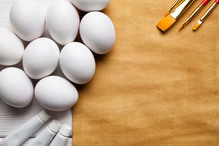 White eggs, paints and brushes on handmade paper sheetの写真素材