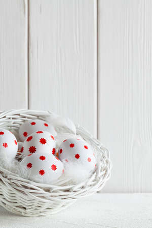 Easter eggs in white basket on white backgroundの写真素材
